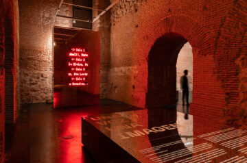 Exhibition Design At Condeduque Center’s Vaulted Hall Plays With Red Light, Mirrors And Reflections