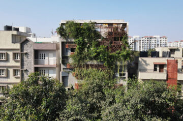 Terracotta tile screens clothe residential facade in india with a green curtain