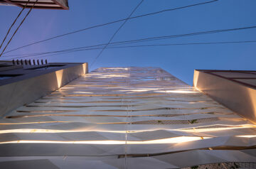 Folded steel ribbons envelope narrow row house in india