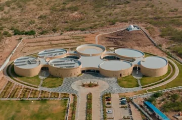 Elliptical stone-clad galleries by ini design studio compose science center in india